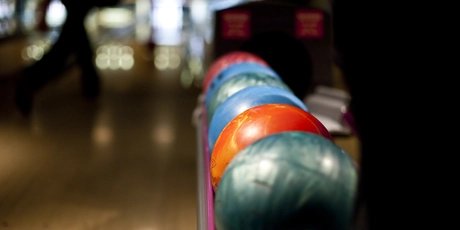 Bunte Bowlingkugeln auf Rack auf Bowling-Bahn