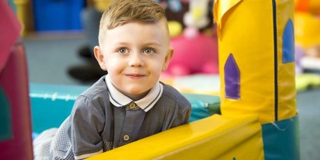 Cheeky little boy playing in a ball pit