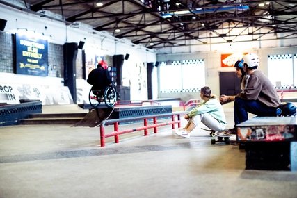 Skatehalle Berlin: Two skaters watch wheelchair skating