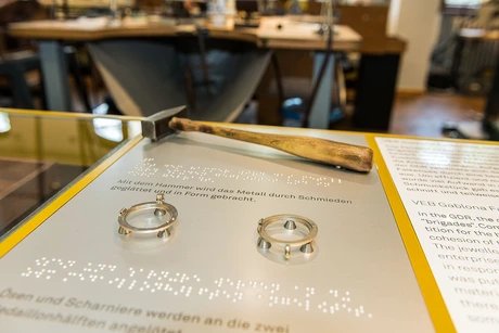 Taststationen ermöglichen auch die haptische Erfahrung der Ausstellung. Die Erläuterungen sind sowohl in Schwarzschrift als auch in Braille zu lesen.