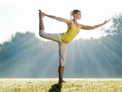Frau praktiziert Yoga im Park