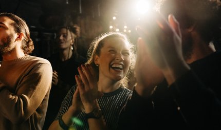 Lachende Frau applaudiert